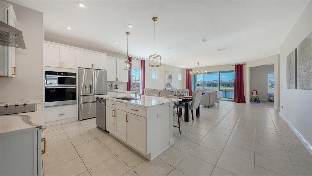 11869 Richmond Trail Parrish, FL 34219 - Photo 15 of 68 a large kitchen with kitchen island a counter top space appliances and a cabinets
