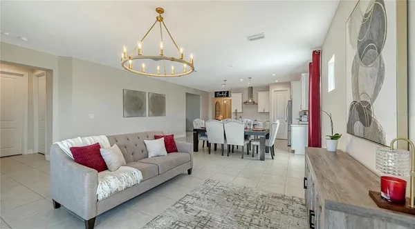 a view of a dining room and livingroom with furniture a rug and a chandelier
