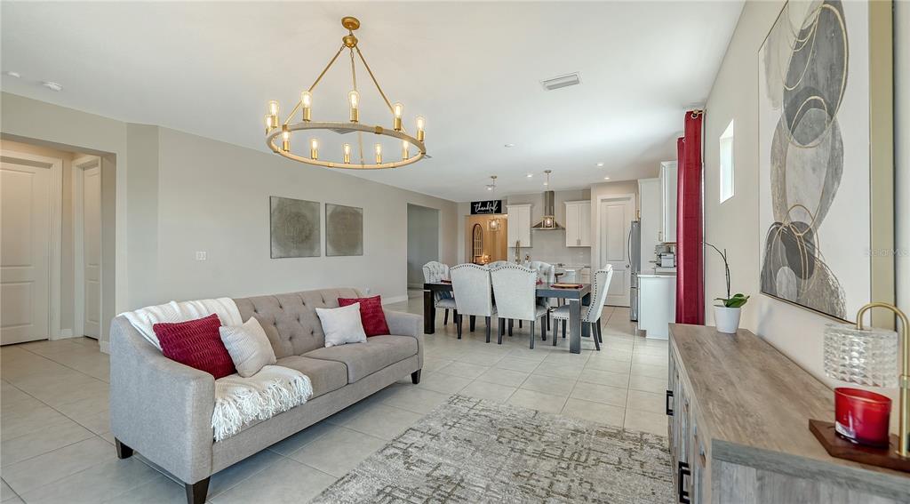 11869 Richmond Trail Parrish, FL 34219 - Photo 16 of 68 a living room with furniture a dining table and a chandelier