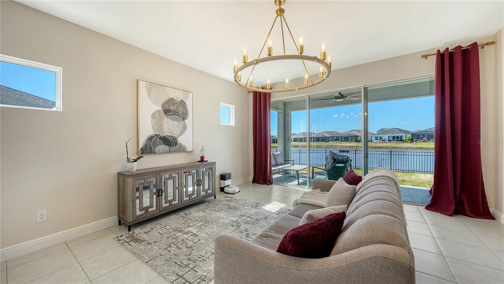 11869 Richmond Trail Parrish, FL 34219 - Photo 20 of 68 a living room with furniture a chandelier and a window