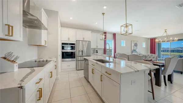 a dining table chairs and a refrigerator in kitchen