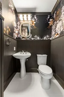 a bathroom with a toilet sink and mirror