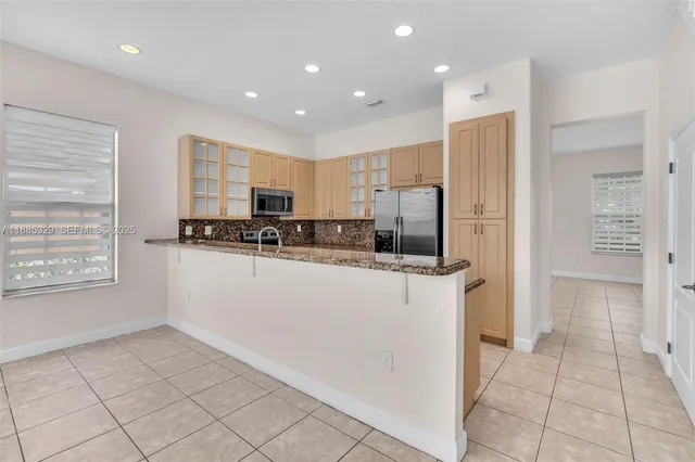 a kitchen with stainless steel appliances granite countertop a stove a sink and a refrigerator