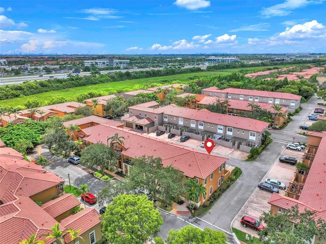 an aerial view of residential houses with outdoor space and ocean view