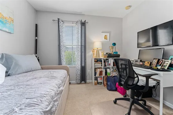 a bedroom with a bed a large window and a flat screen tv