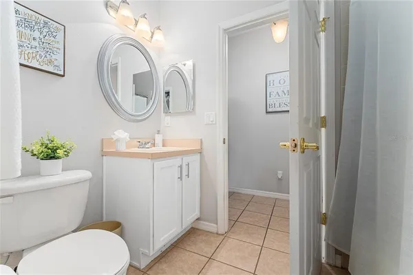 a bathroom with a granite countertop toilet a sink and a mirror