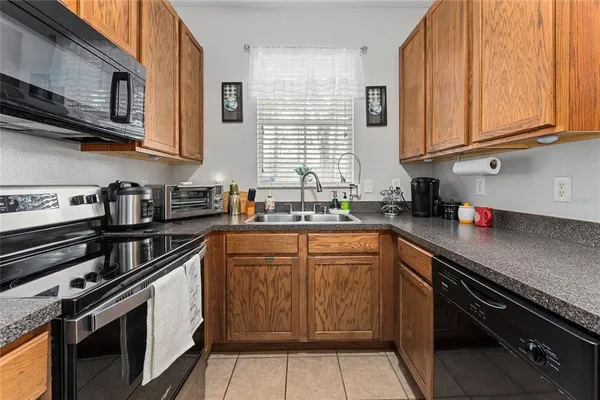 a kitchen with stainless steel appliances granite countertop white cabinets sink and window