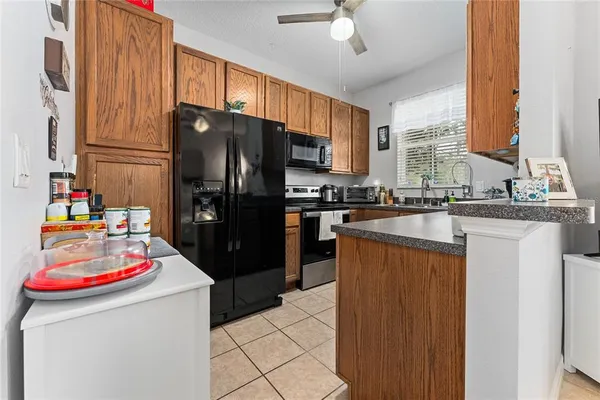 a kitchen with stainless steel appliances granite countertop a refrigerator a stove and a sink