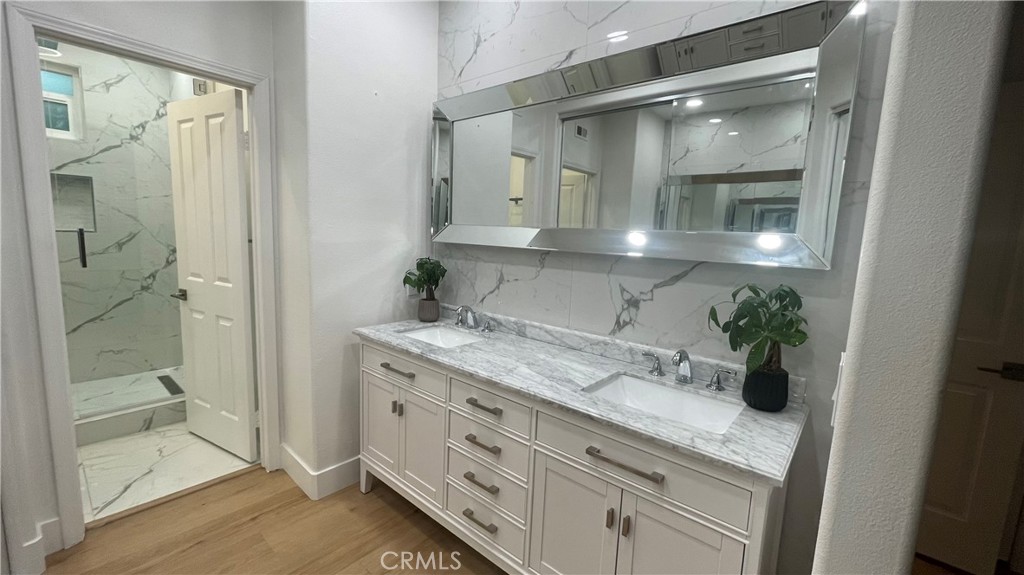 15 Marsala Irvine, CA 92606 - Photo 17 of 31 a bathroom with a granite countertop sink a mirror and a shower