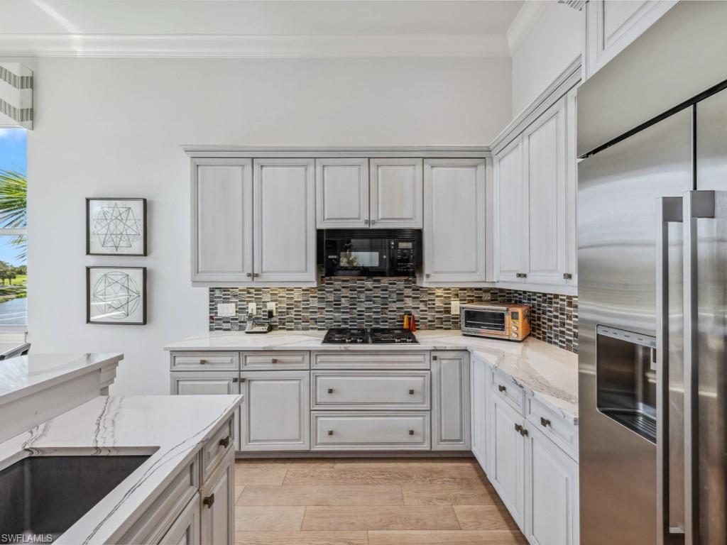 16985 Porta Vecchio Way, Unit 202 Naples, FL 34110 - Photo 13 of 50 a kitchen with a sink stove and refrigerator