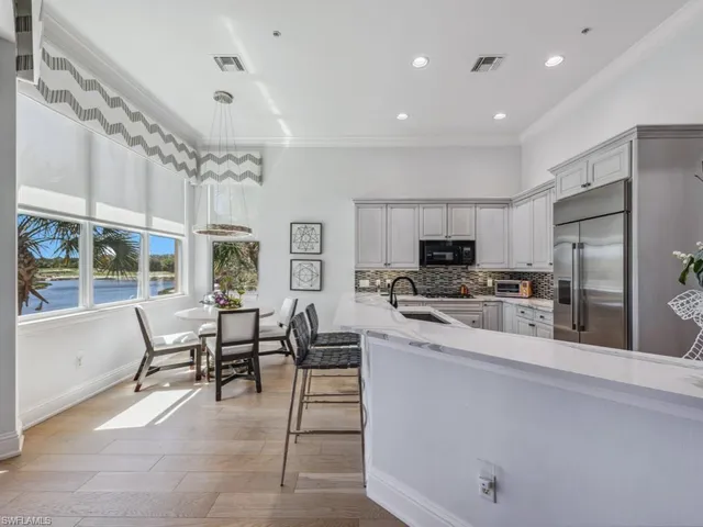 a large open kitchen with stainless steel appliances granite countertop a stove and a refrigerator with cabinets