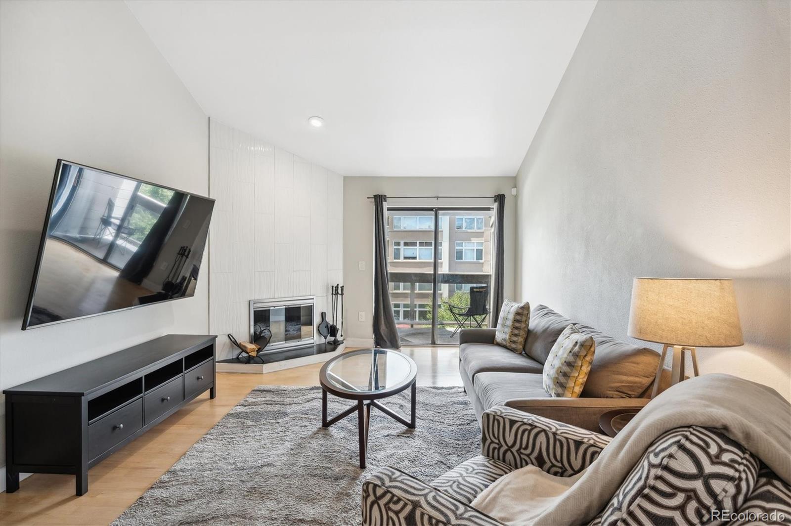350 Detroit Street, Unit 413 Denver, CO 80206 - Photo 9 of 24 a living room with furniture and a flat screen tv