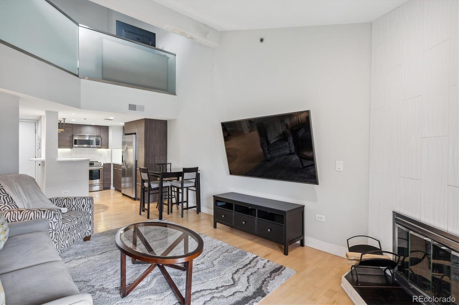 350 Detroit Street, Unit 413 Denver, CO 80206 - Photo 10 of 24 a living room with furniture a flat screen tv and kitchen view