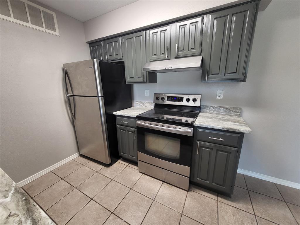a kitchen with stainless steel appliances granite countertop a refrigerator a stove and a cabinets