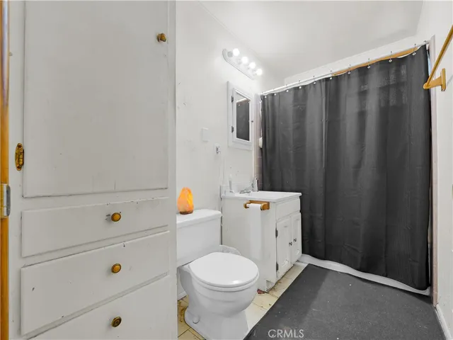 a bathroom with a toilet and a shower curtain