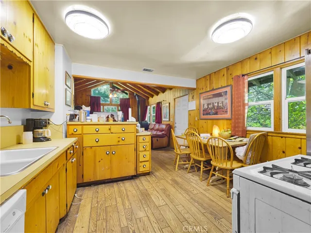 a kitchen with a stove a refrigerator and wooden floor