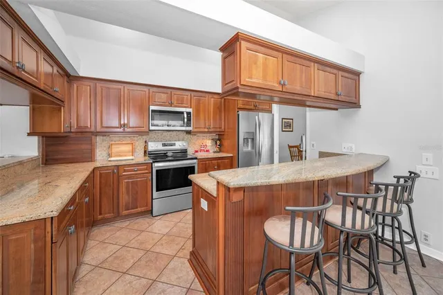 a kitchen with stainless steel appliances granite countertop a stove a sink dishwasher and a microwave oven with cabinets