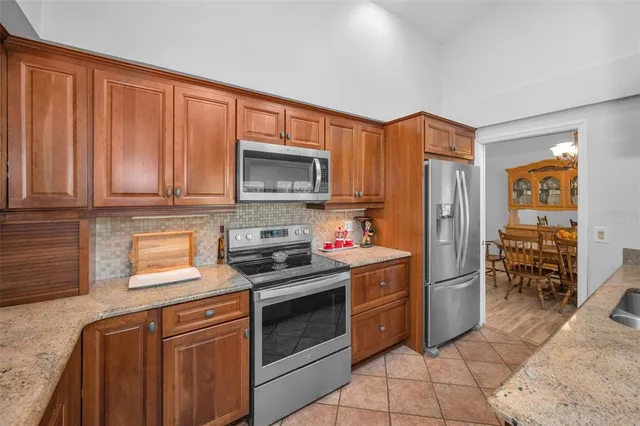 a kitchen with stainless steel appliances granite countertop a refrigerator stove top oven and sink