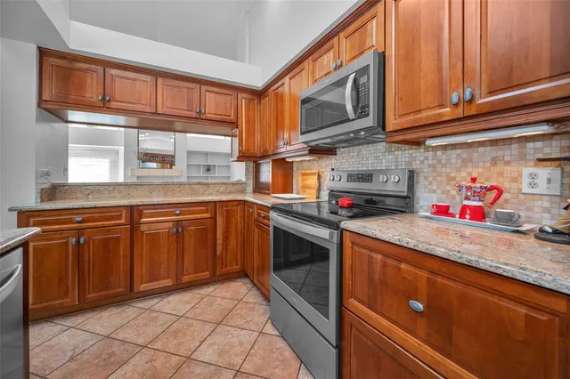 a kitchen with stainless steel appliances granite countertop a sink stove and cabinets