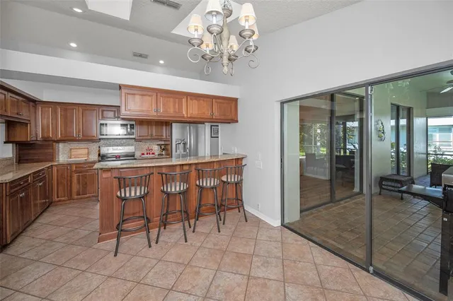a kitchen with kitchen island granite countertop a sink counter top space appliances and cabinets