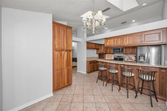 a kitchen with stainless steel appliances granite countertop a refrigerator and a stove top oven