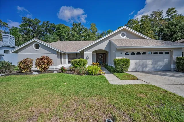 a view of a yard in front of a house with large trees
