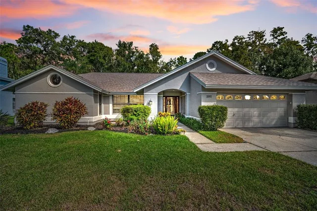a view of a yard in front of a house with large trees