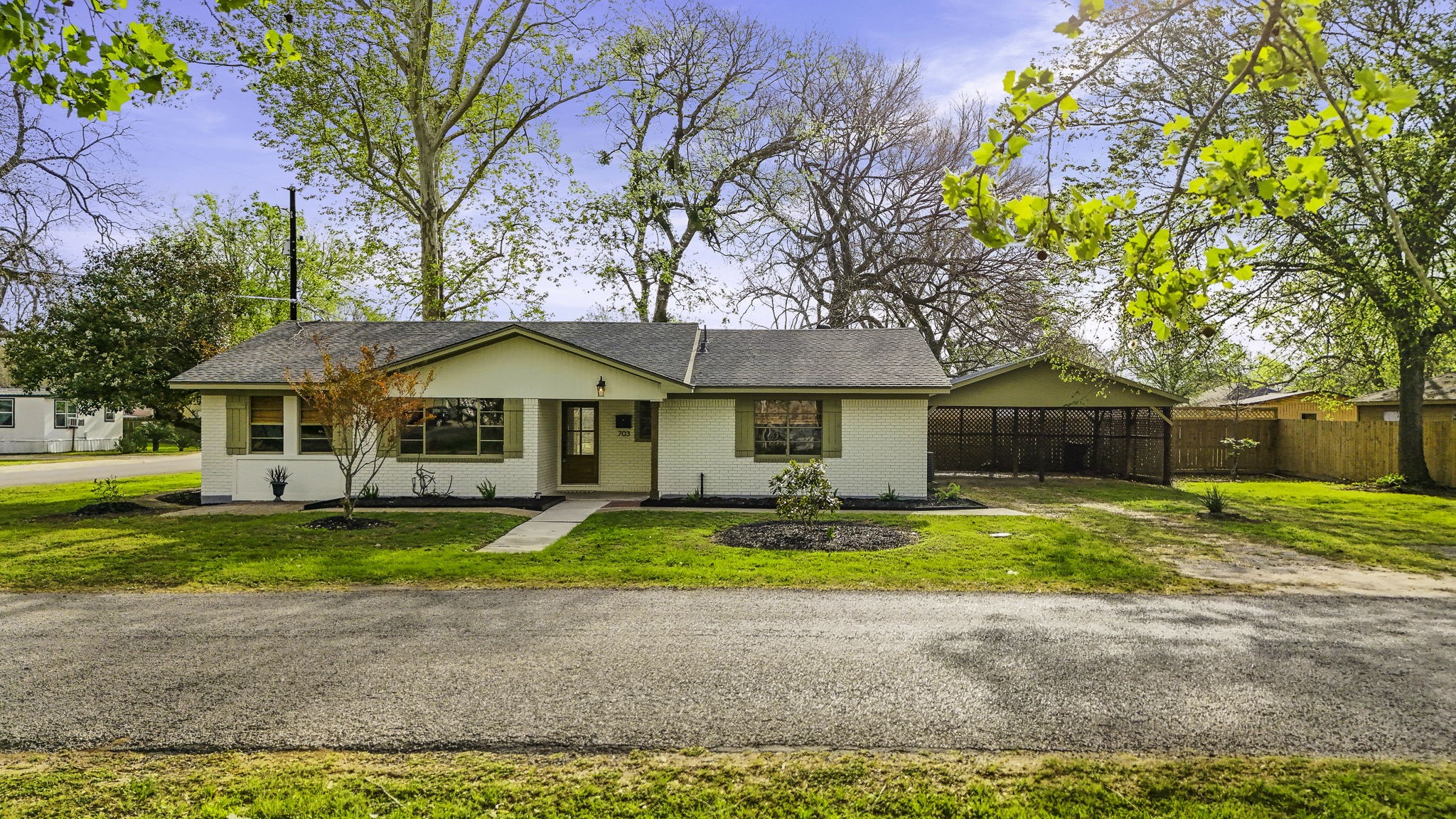 703 Austin Street Columbus, TX 78934 - Photo 2 of 37 a front view of a house with swimming pool and sitting area