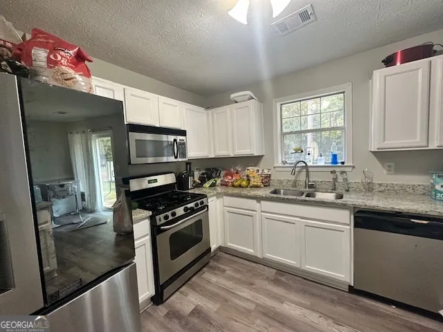 a kitchen with a sink stove and microwave