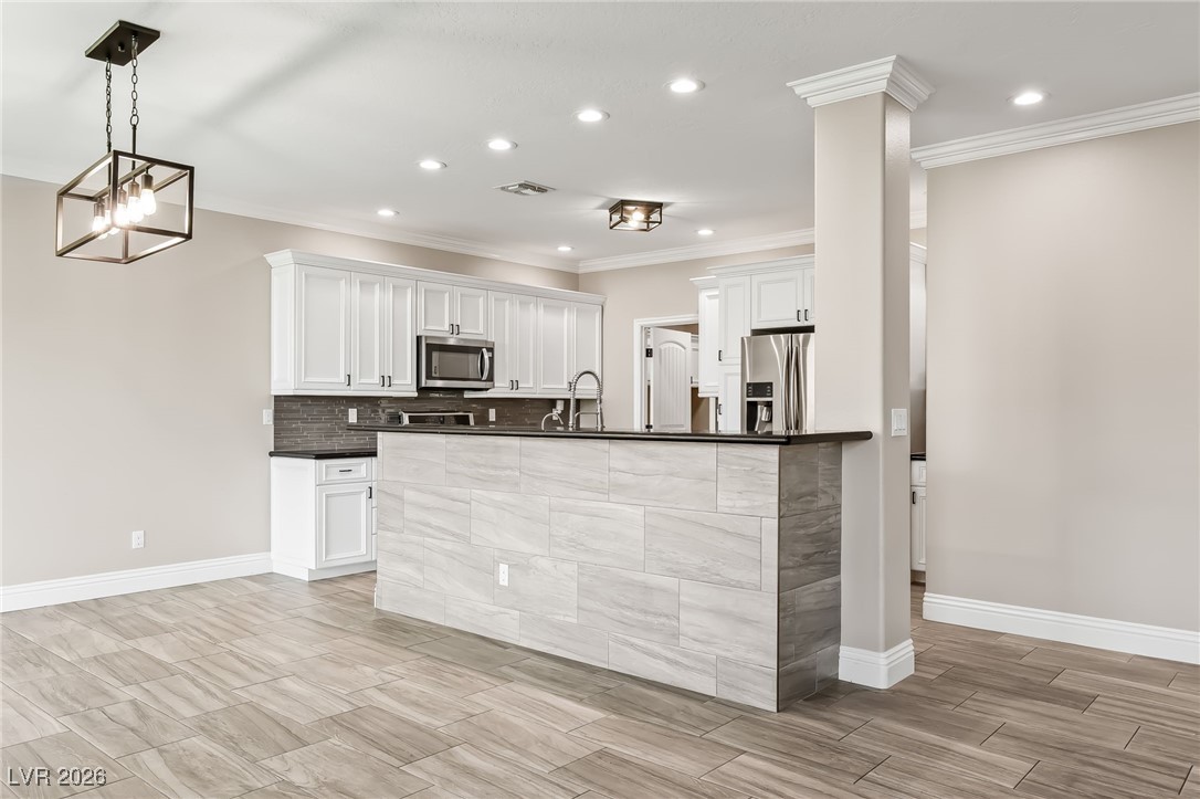 3807 Chapels Royal Street Laughlin, NV 89029 - Photo 13 of 62 Kitchen with white cabinets, appliances with stainless steel finishes, decorative light fixtures, ornamental molding, and recessed lighting
