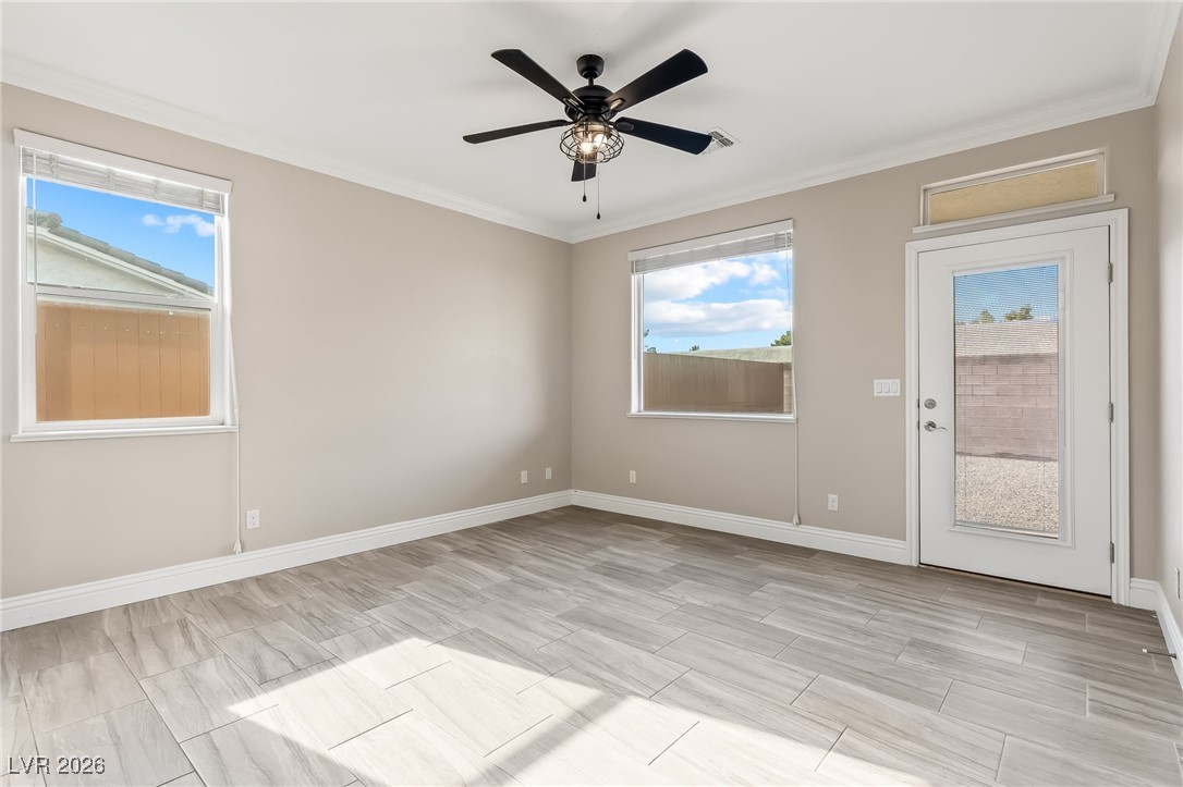 3807 Chapels Royal Street Laughlin, NV 89029 - Photo 22 of 62 Primary bedroom with ornamental molding, ceiling fan, and wood finish floors