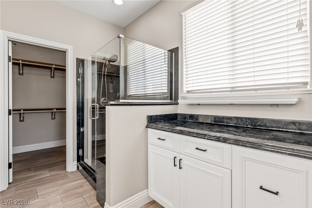 3807 Chapels Royal Street Laughlin, NV 89029 - Photo 25 of 62 Full Primary Ensuite Bathroom with wood tiled floors, a shower stall, and a spacious closet