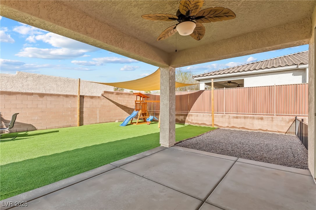 3807 Chapels Royal Street Laughlin, NV 89029 - Photo 44 of 62 Fenced backyard with ceiling fan, a patio area, and a playground