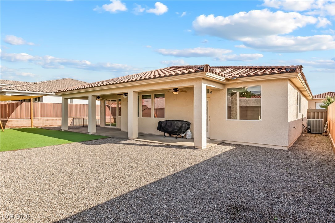 3807 Chapels Royal Street Laughlin, NV 89029 - Photo 48 of 62 Rear view of property with a ceiling fan, a fenced backyard, a tiled roof, and stucco siding