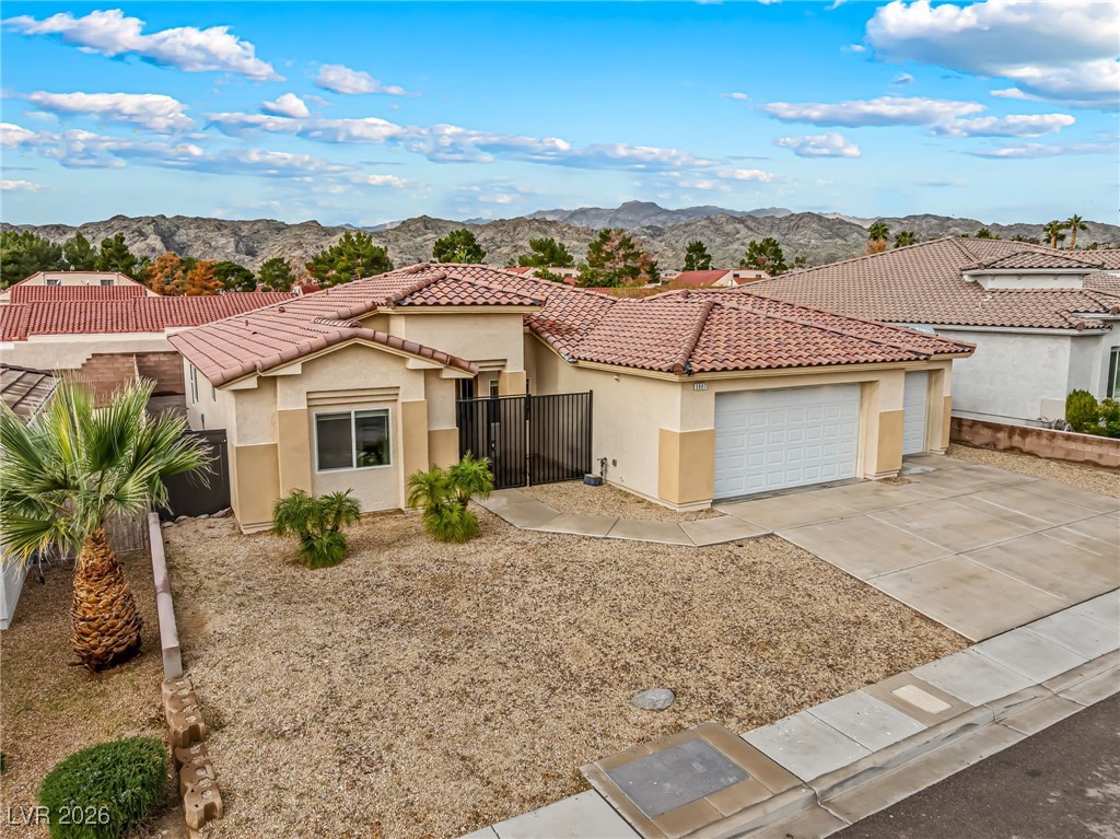 3807 Chapels Royal Street Laughlin, NV 89029 - Photo 54 of 62 Mediterranean / spanish home with stucco siding, a mountain view, concrete driveway, and a garage