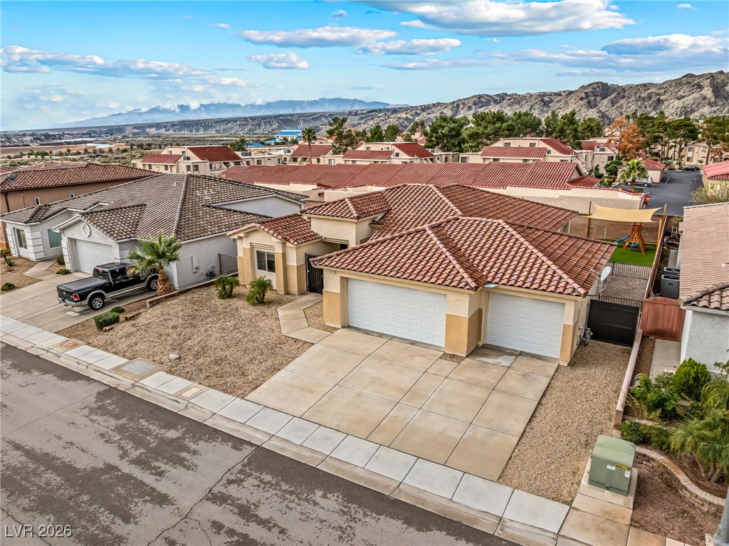 3807 Chapels Royal Street Laughlin, NV 89029 - Photo 56 of 62 View of front facade featuring a residential view, an attached garage, driveway, and a mountain view