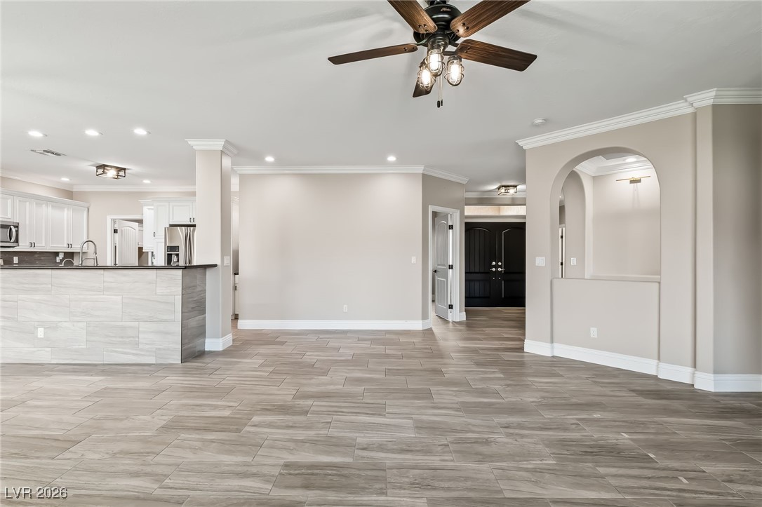 3807 Chapels Royal Street Laughlin, NV 89029 - Photo 8 of 62 Unfurnished living room featuring a ceiling fan, crown molding, and recessed lighting