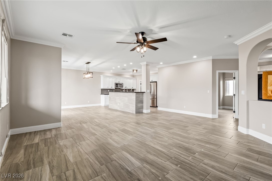 3807 Chapels Royal Street Laughlin, NV 89029 - Photo 9 of 62 Unfurnished living room featuring recessed lighting, ornamental molding, ceiling fan, and wood tiled floors