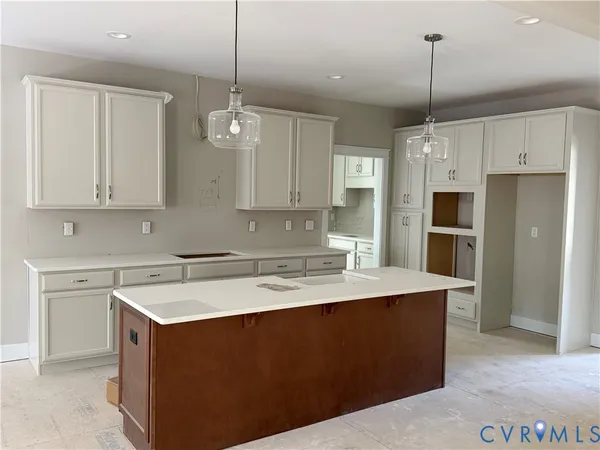a kitchen with a sink a stove a refrigerator and white cabinets