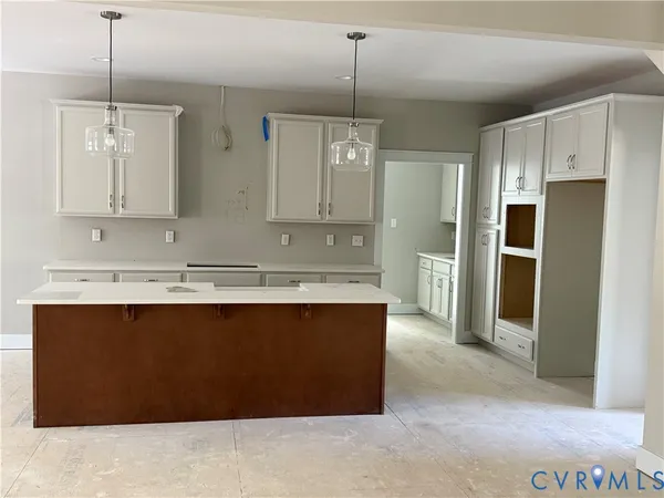 a view of kitchen island refrigerator sink and cabinets