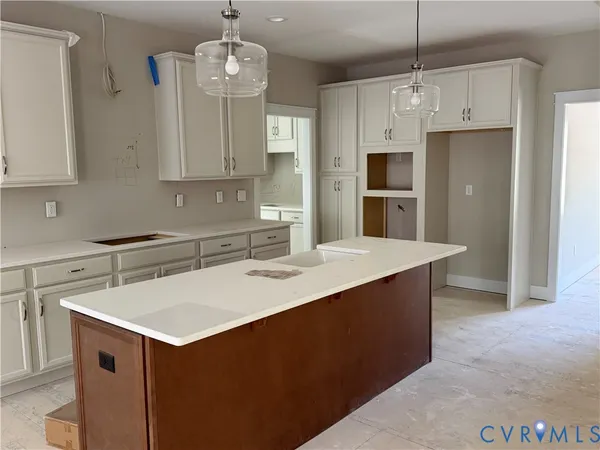 a kitchen with kitchen island granite countertop a sink a center island and stainless steel appliances