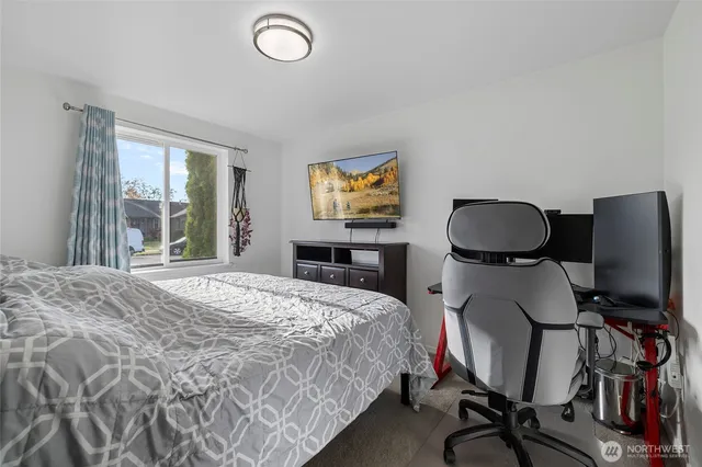 a bedroom with a bed and a flat screen tv