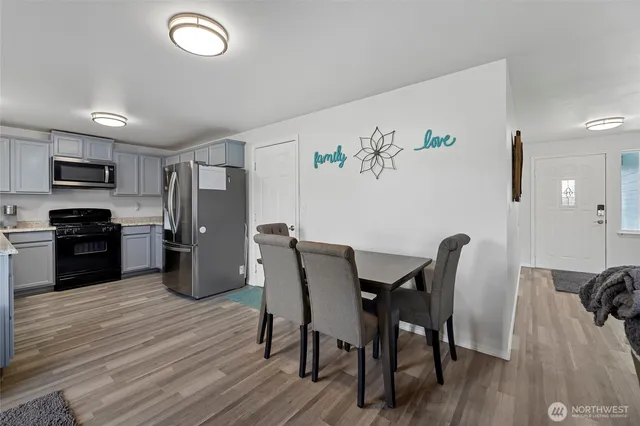a view of a dining room with furniture wooden floor and a refrigerator