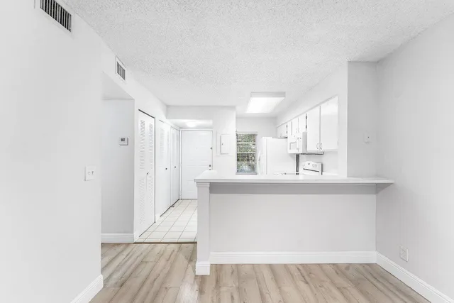 a view of a kitchen with wooden floor and a window