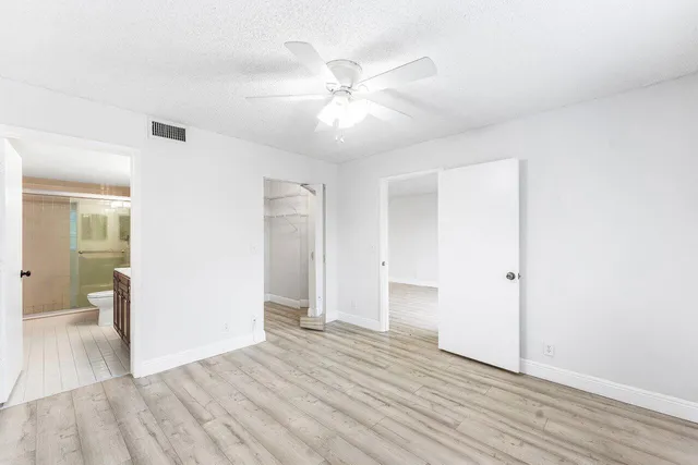 a view of an empty room and window and wooden floor