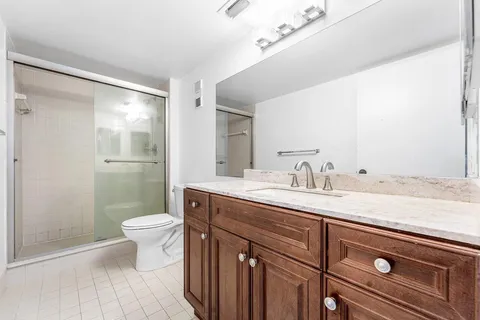 a bathroom with a granite countertop sink a toilet and a mirror
