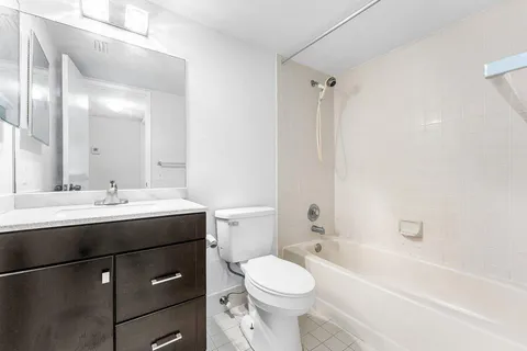 a bathroom with a sink toilet vanity and shower