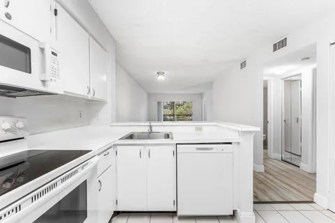 a kitchen with a sink stove and cabinets