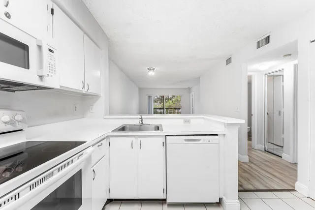 a kitchen with a sink stove and cabinets
