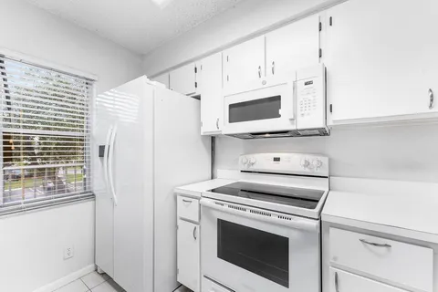 a kitchen with cabinets stainless steel appliances and a counter space